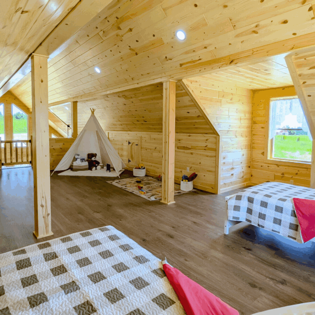 The interior loft of a Trophy Peak series home with two twin beds and a play area for children